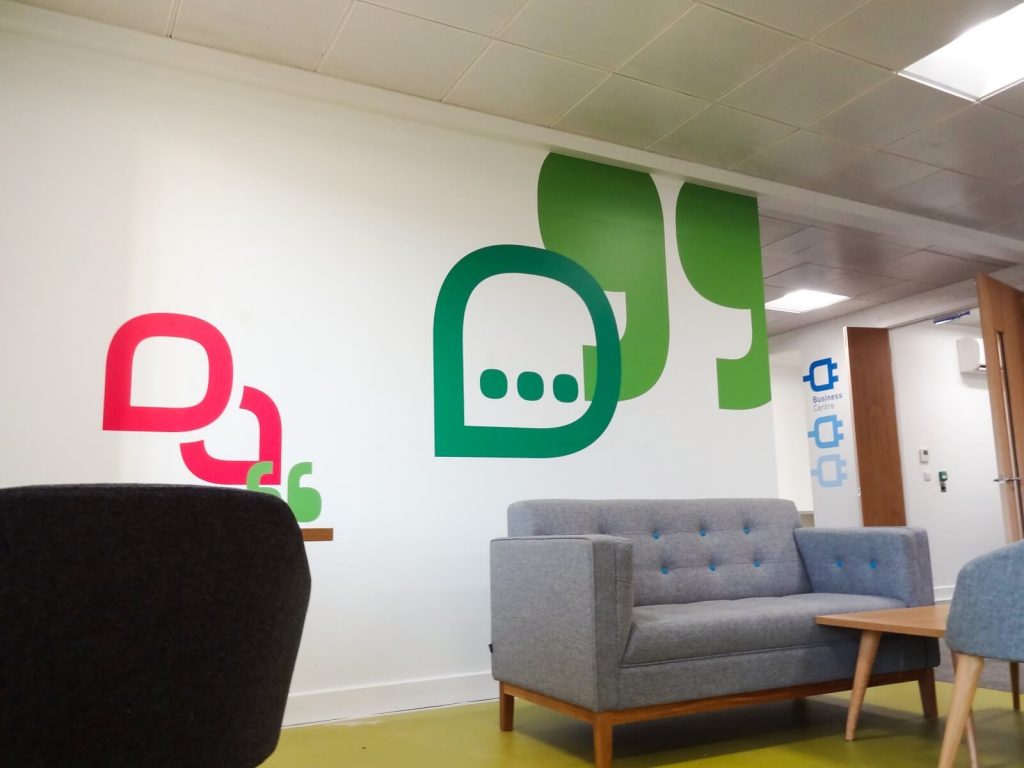 Vinyl wall graphic sign in reception area with chairs and table 